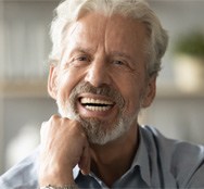 man smiling after getting dentures  