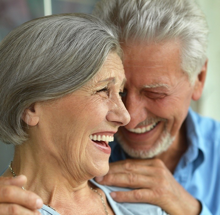 Man and woman laughing together after sedation dentistry visit
