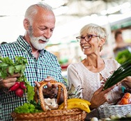 Husband and wife getting healthy veggies at a farmer’s market