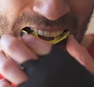 Close up of sporty guy inserting a mouthguard