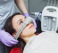 Dental assistant placing nasal mask on patient