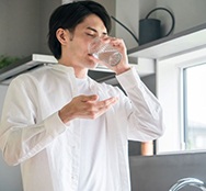 Man drinking water after swallowing a pill